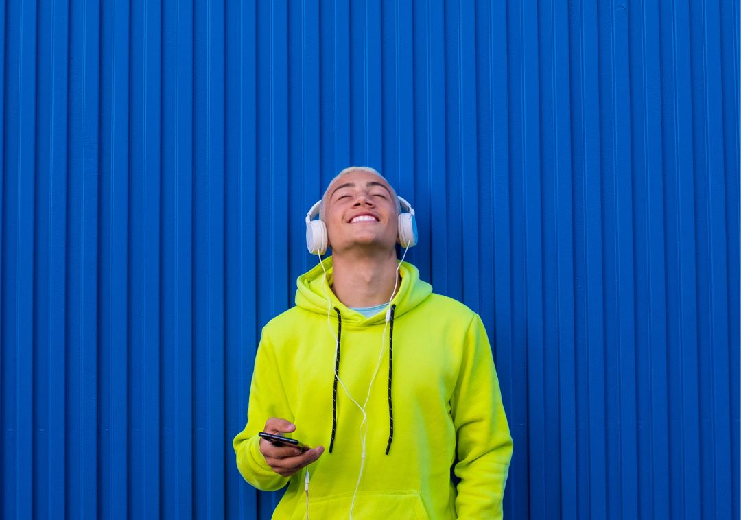 one young man or teenager millennial listening music with his phone and headphones