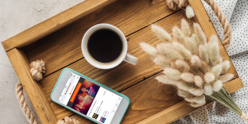 Top View of Cup of Coffee and Smartphone with Soundcloud Website on Screen on Tray with Lagurus