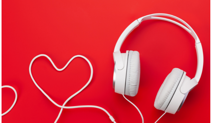 White wired headphones, with the wire shaped into a heart. Red background. The Podcast and YouTube Ads That Stuck with Us