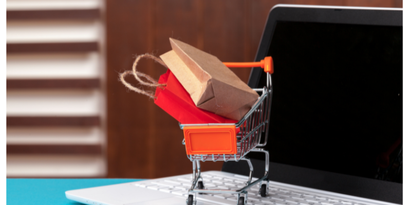 Online shopping concept. Shopping cart, laptop on the desk