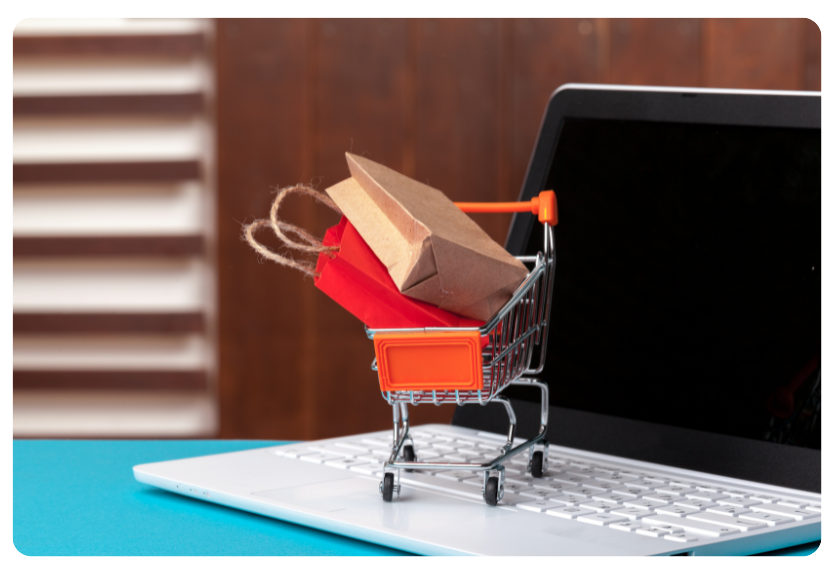 Online shopping concept. Shopping cart, laptop on the desk