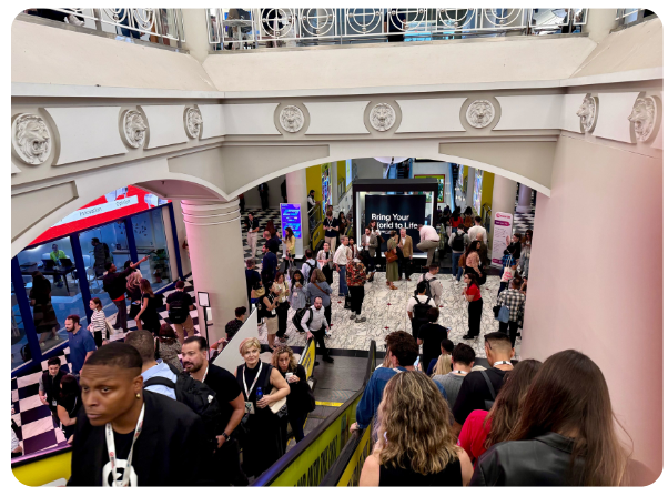 Attendees fill the entrance and escalators at The Penn District during Advertising Week New York 2025, gathering to explore sessions, exhibits, and networking in the Podcast Zone.