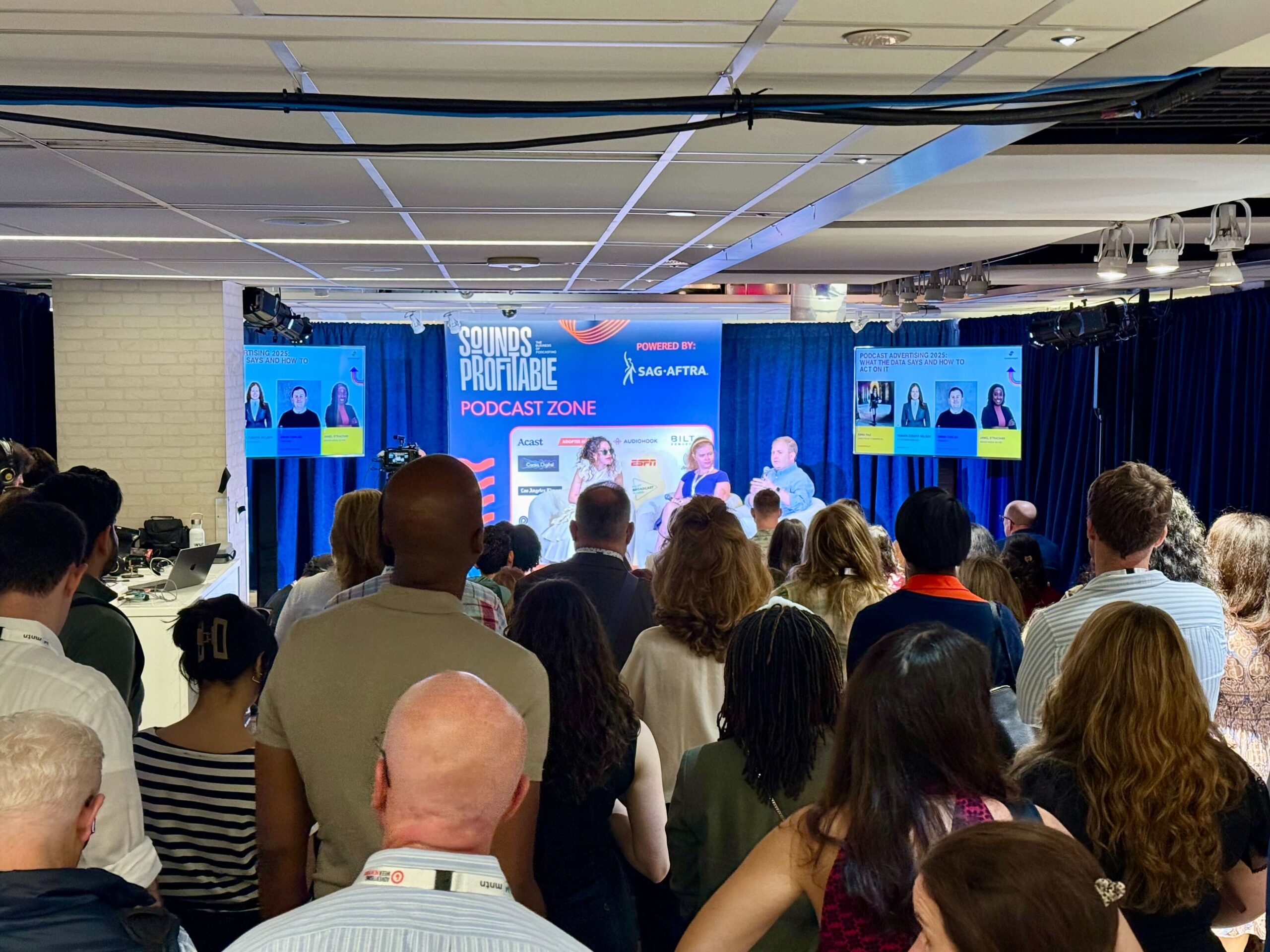 Audience watching a live panel in the Podcast Zone at Advertising Week New York 2025, featuring industry leaders discussing podcast advertising trends.