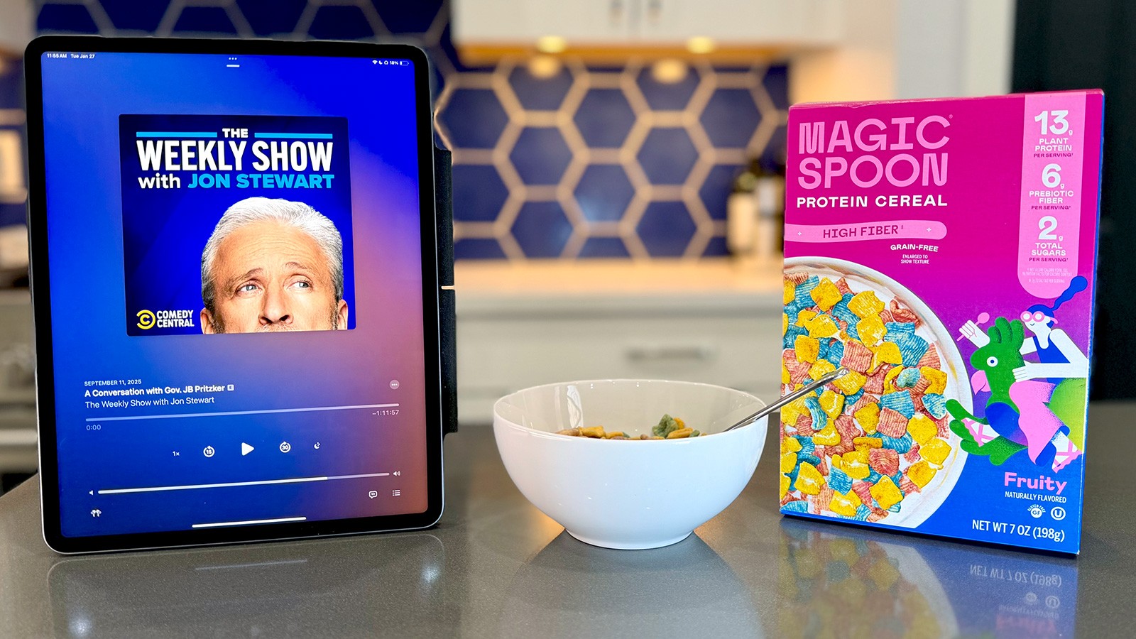Magic Spoon cereal displayed beside a tablet playing The Weekly Show with Jon Stewart, the podcast featuring ADOPTER Media’s Ambies-nominated ad read.