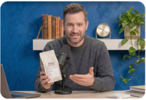Podcast host making direct eye contact with the camera while holding up a coffee product during a YouTube ad read