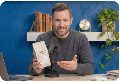 Podcast host making direct eye contact with the camera while holding up a coffee product during a YouTube ad read