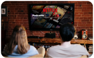 Two people watching a Netflix podcast on a large flat-screen TV in a modern living room