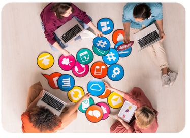 Overhead view of four people working on laptops surrounded by colorful marketing channel icons