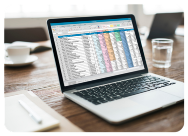 Open laptop displaying a colorful spreadsheet on a wooden desk
