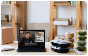 Podcast host delivering a host-read ad for a meal delivery brand, with meal prep containers on the desk