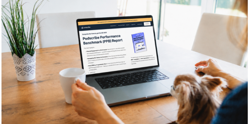 Person with a dog viewing the Podscribe Q2 2026 Performance Benchmark Report pre-request page on a laptop